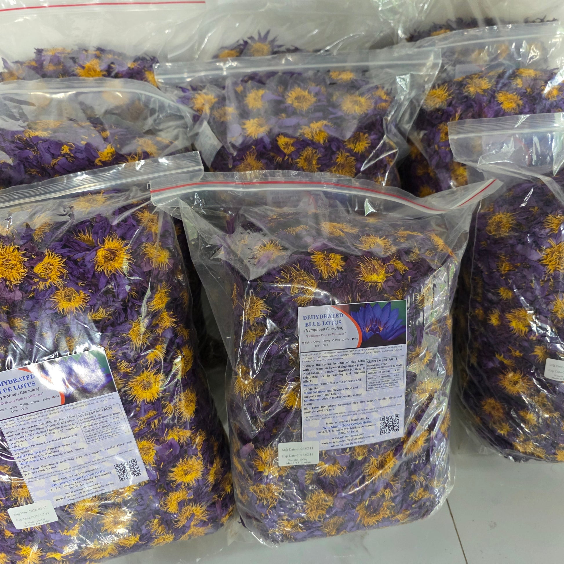 Multiple bags of dried flowers with labels on a white surface